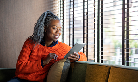 Woman on couch looking at tablet